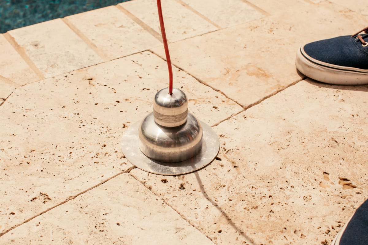 Aloha's ultra-sensitive deck plate pinpointing a leak beneath a travertine pool deck
