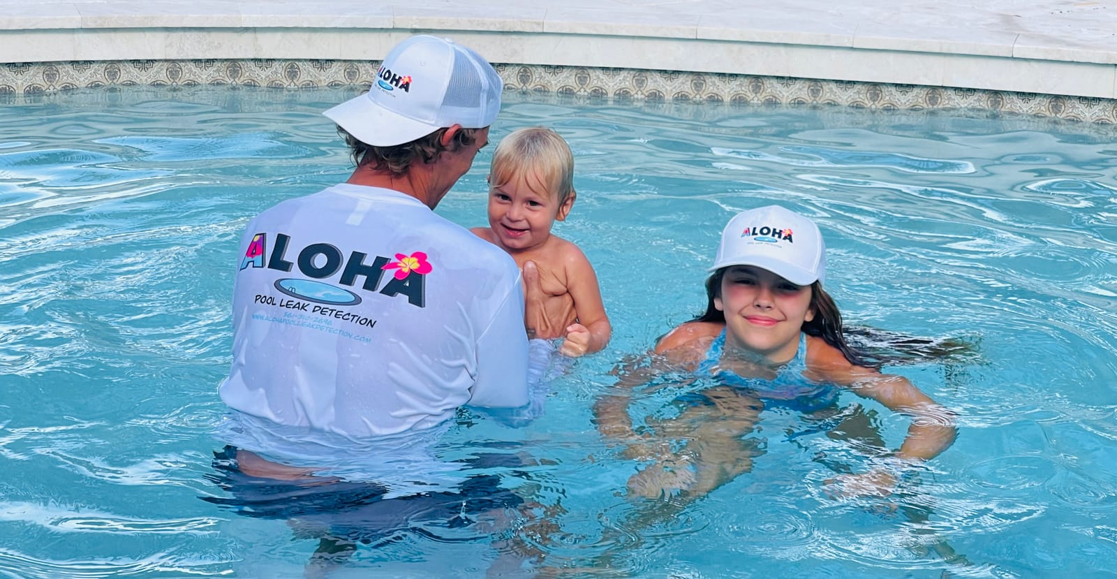 Tyler Thompson of Aloha Pool Leak Detection in a Jupiter FL pool with his kids, all wearing Aloha caps