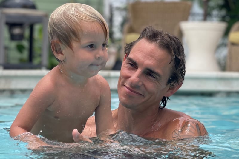 Tyler Thompson smiling in the pool with his young son after a leak repair
